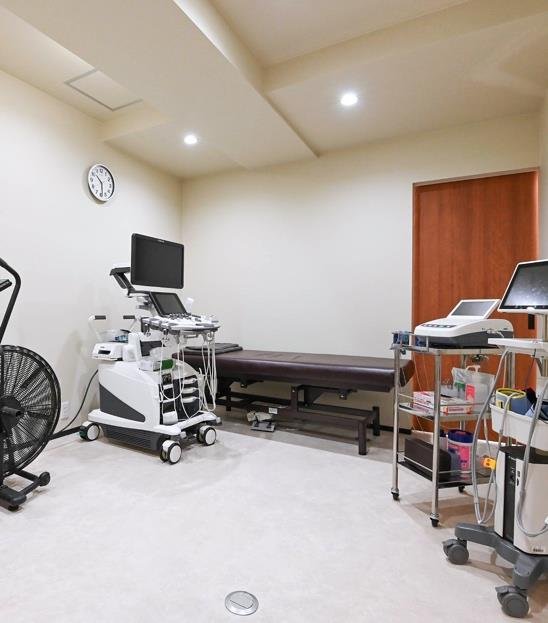 GoCLN clinical assessment room with examination bed and medical equipment, from the MIRAI brochure.